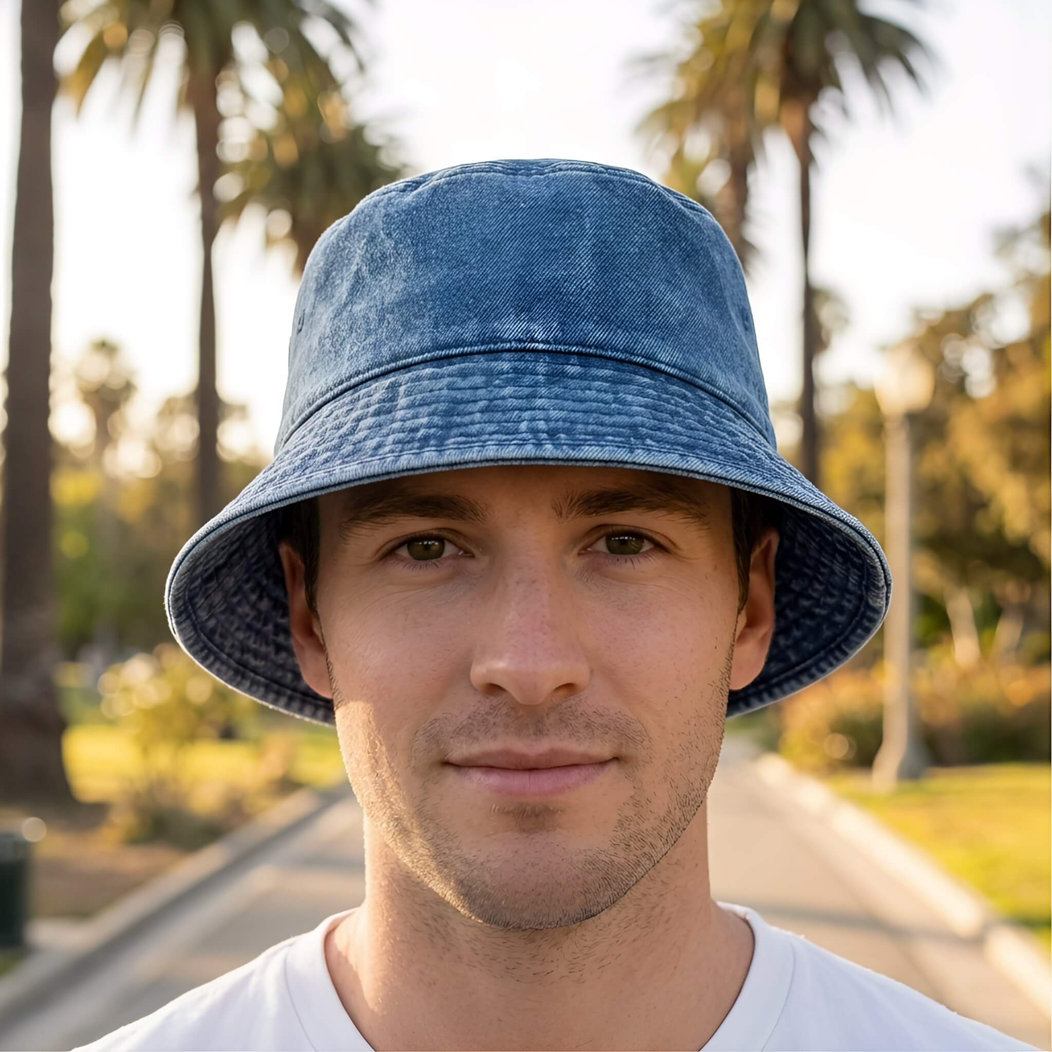 A male model wearing a Meriple navy blue mens bucket hat in the UK sun.
