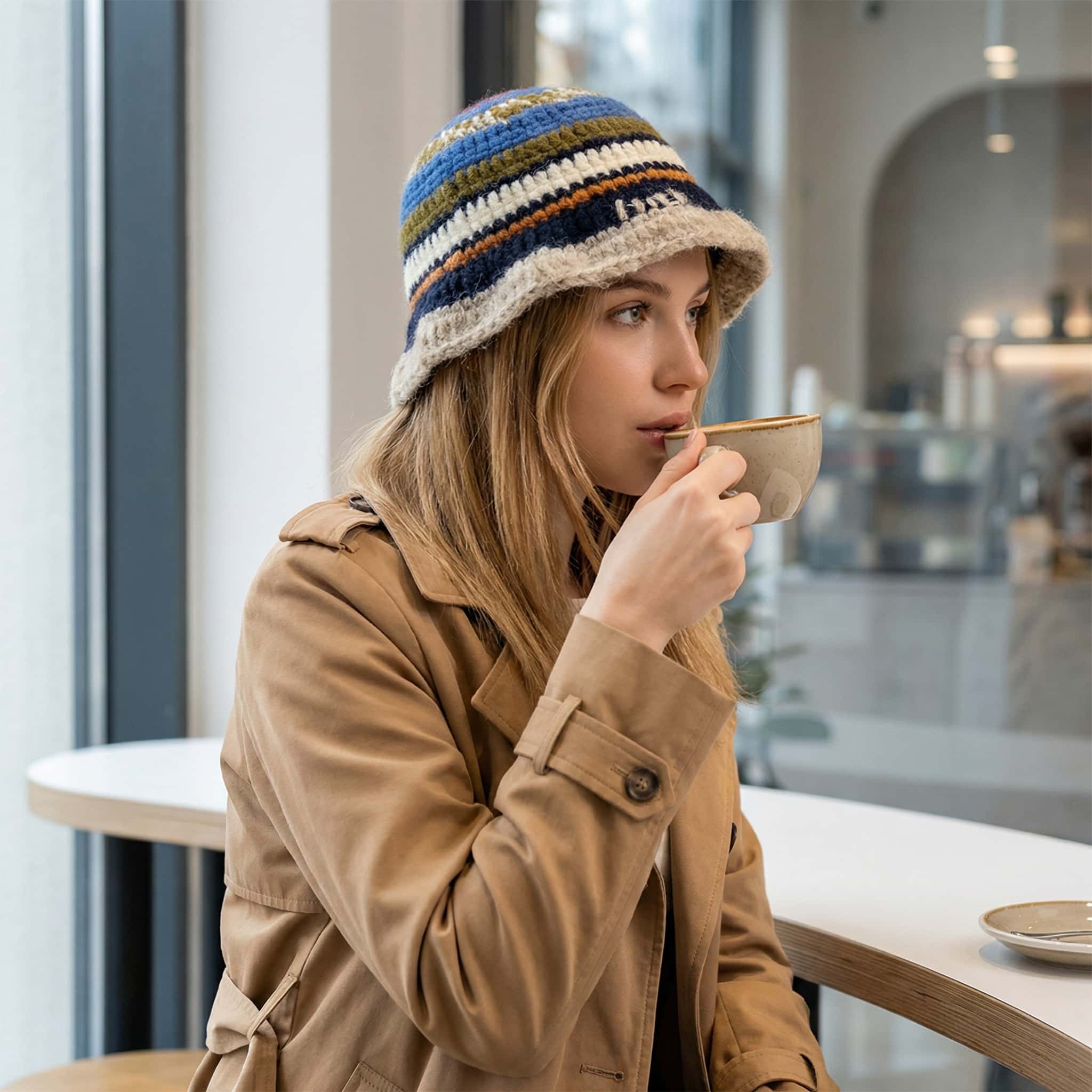 woman wearing handmade knit bucket hat styled with camel coat in winter street