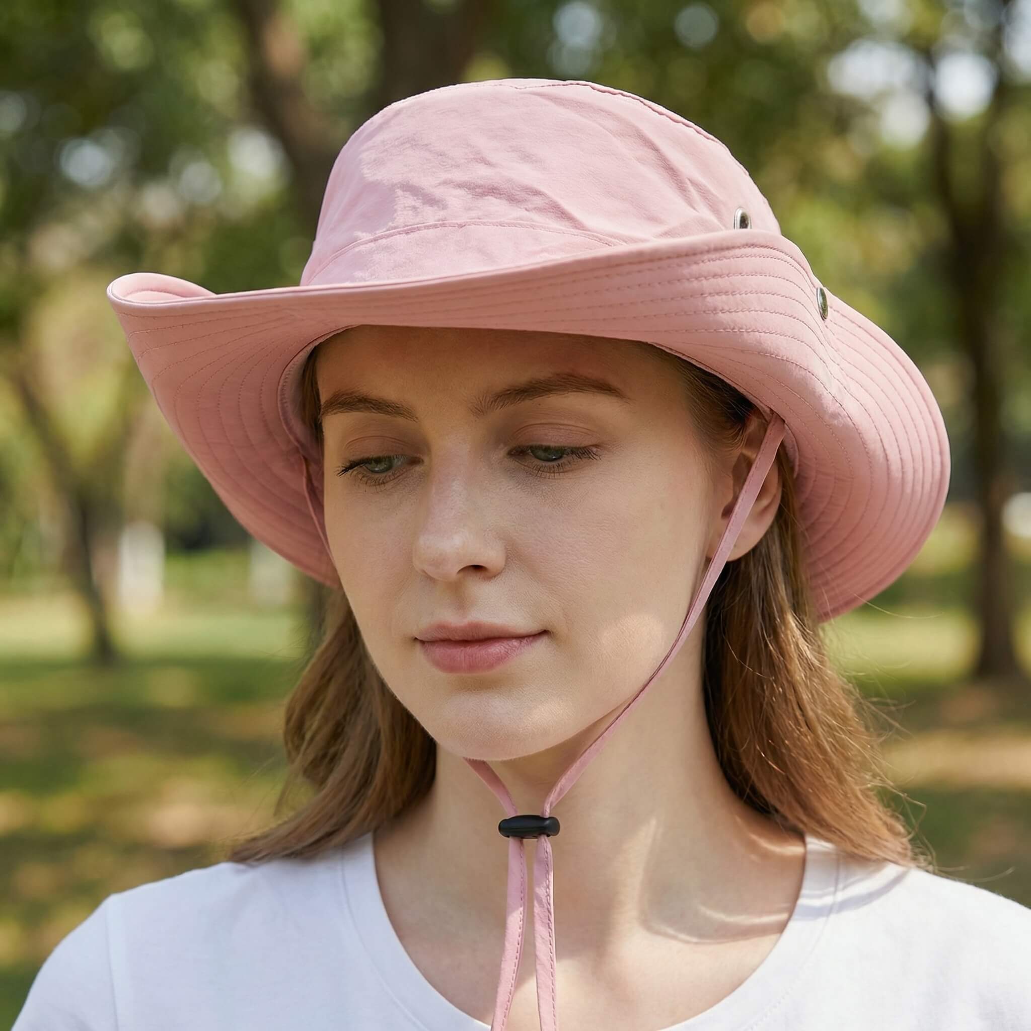 Woman smiling in MERIPLE light pink wide brim quick-dry sun bucket hat, perfect for British summer